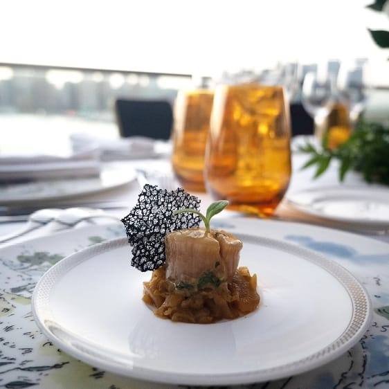 Plated fine-dining course with a view over the water