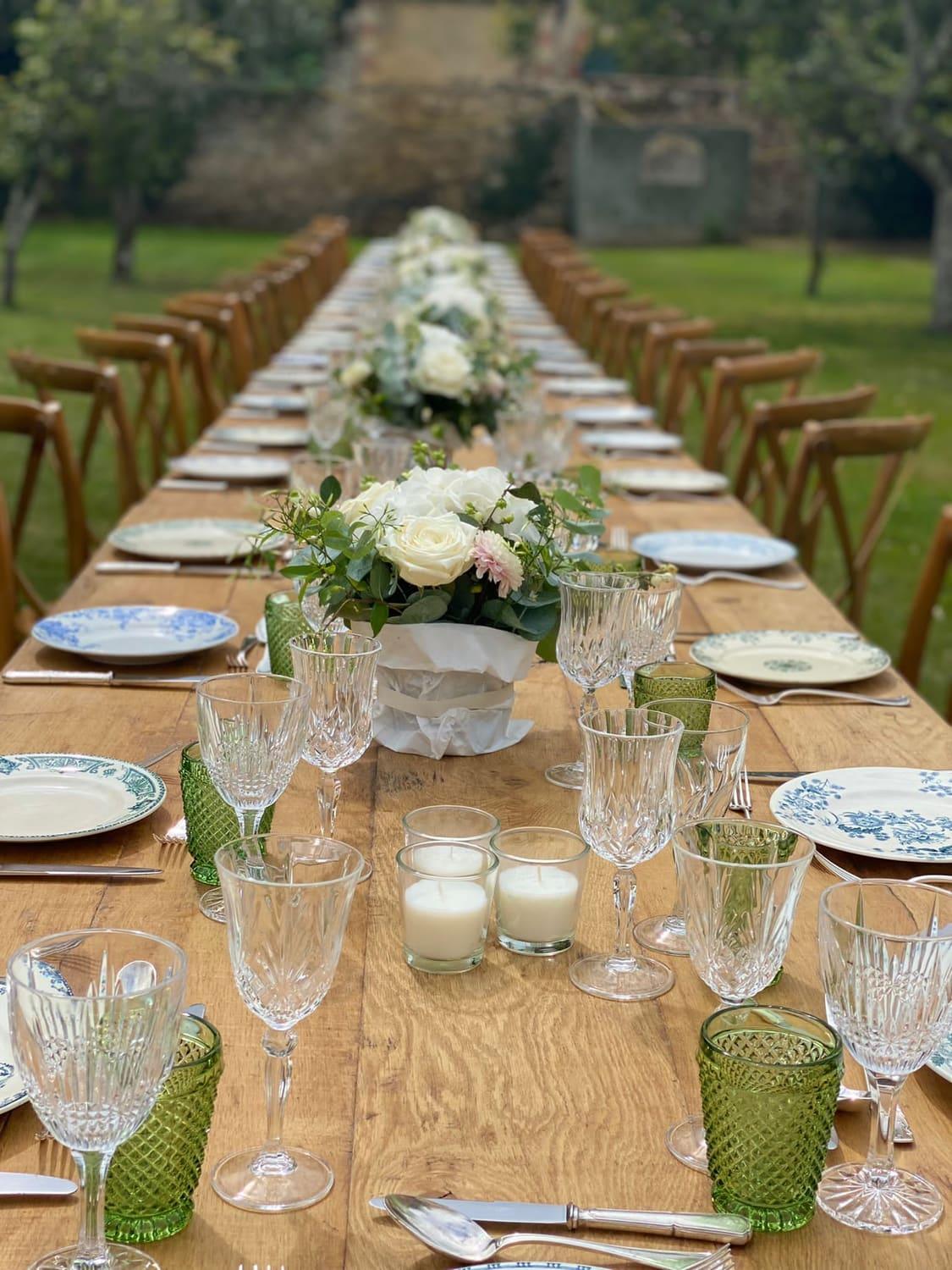 Long garden banquet table dressed with white roses and crystal