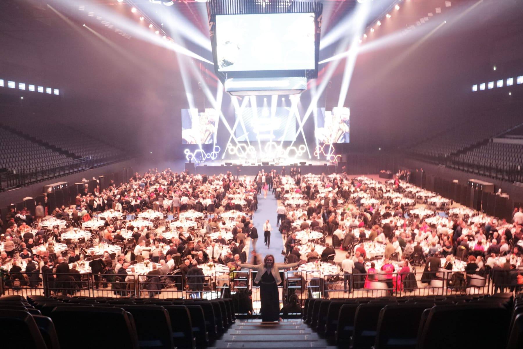 Full LDLC Arena from the stands, hundreds of FFF volunteers dining along a central runway toward the stage