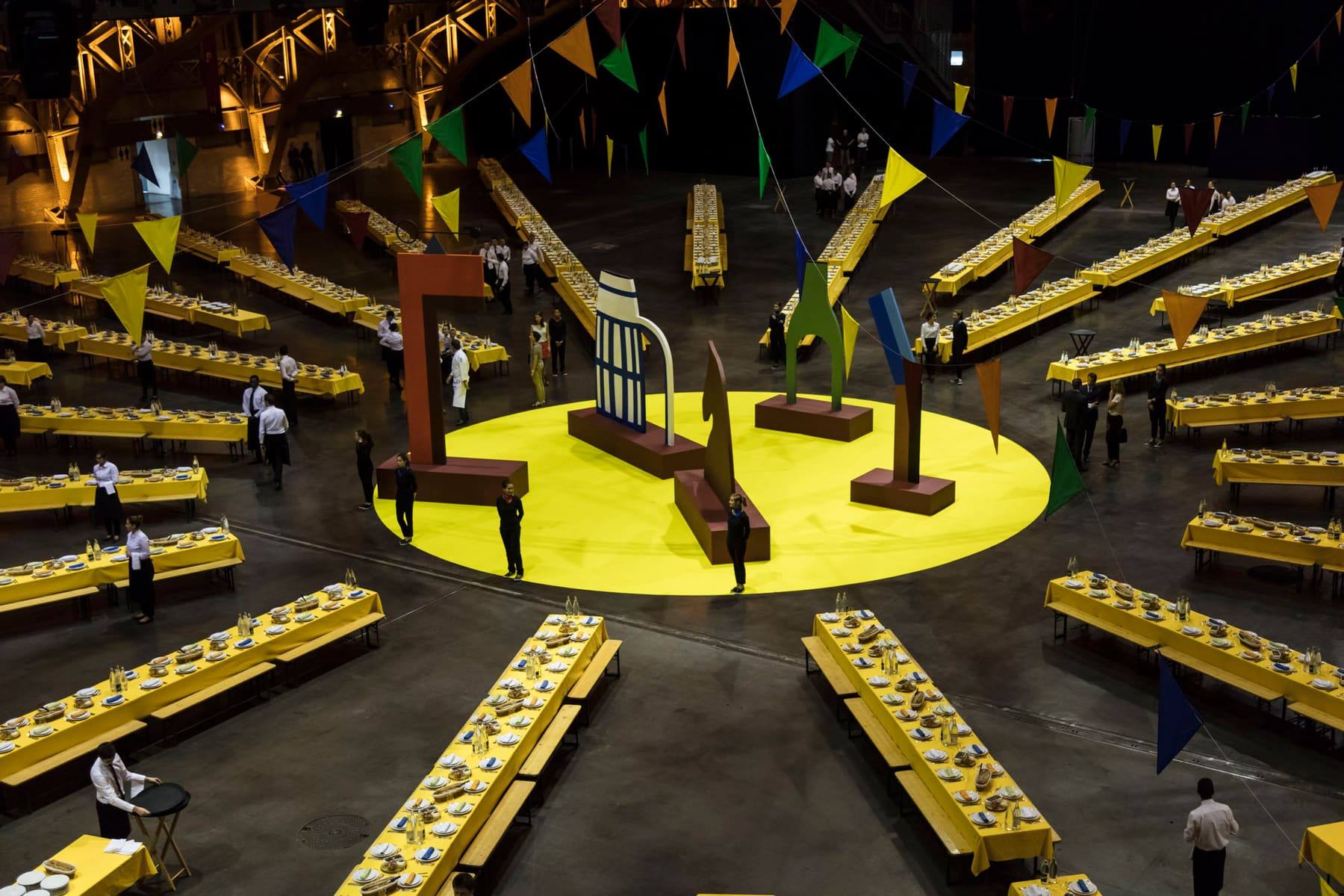 Overhead of the Halles Tony Garnier with yellow banquet tables radiating around a central stage