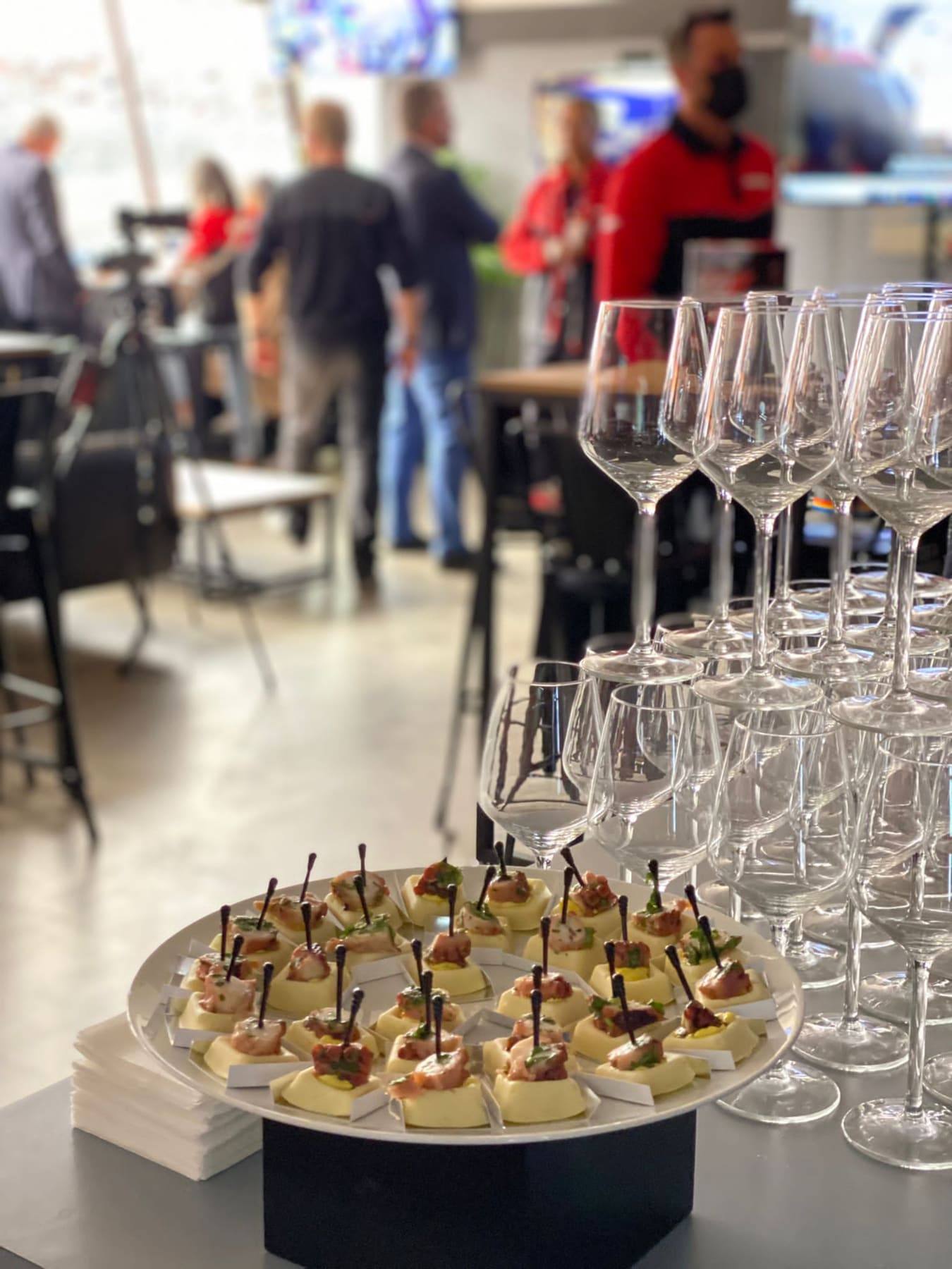Tray of tartare canapés beside ranks of wine glasses in the race-paddock lounge