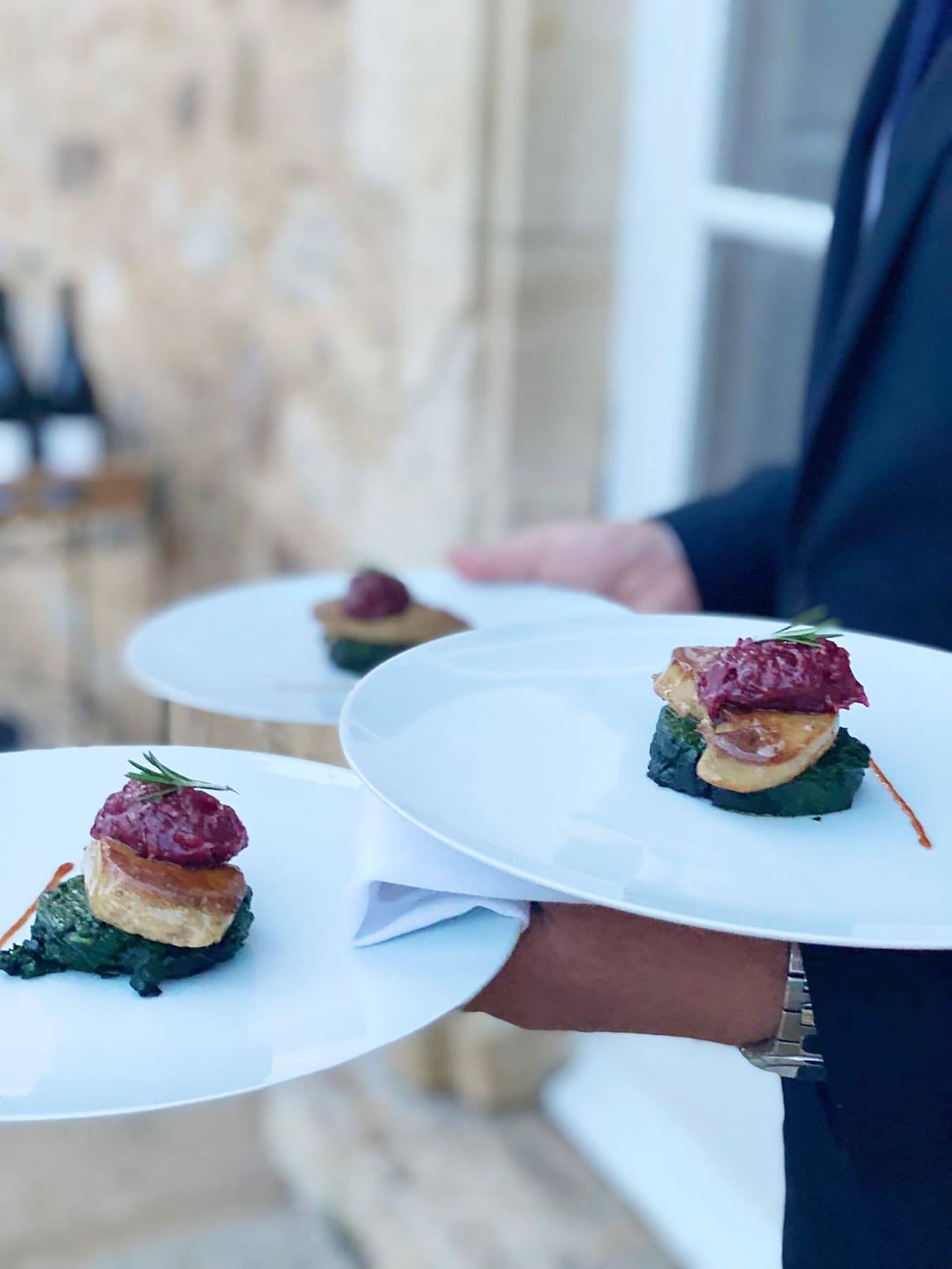 Plated sea bass with lobster and saffron broth, multiple covers ready to serve