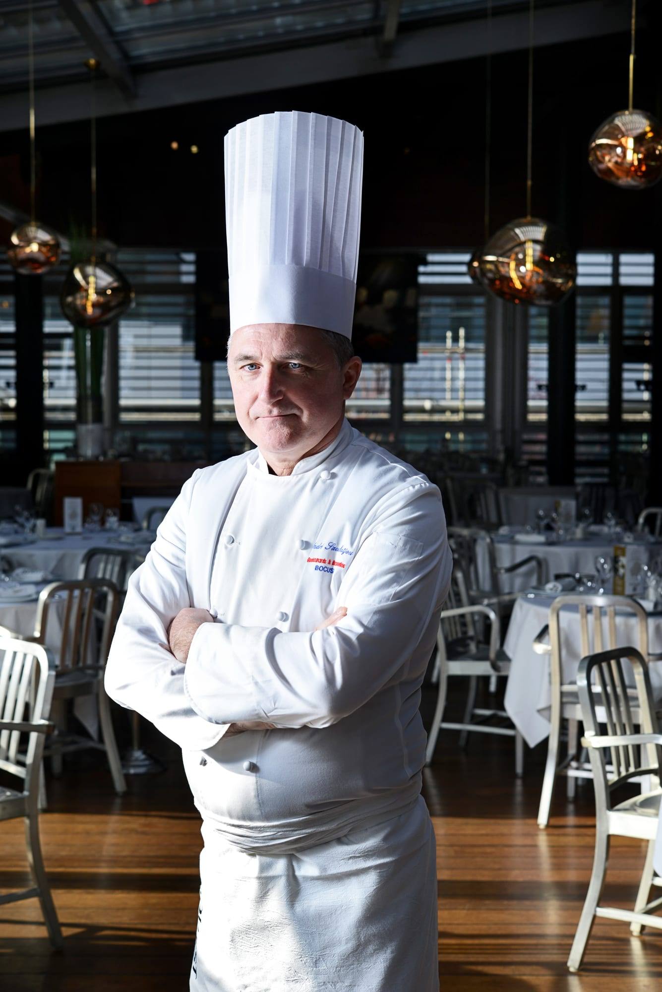 Portrait d'un chef en toque dans une brasserie Bocuse