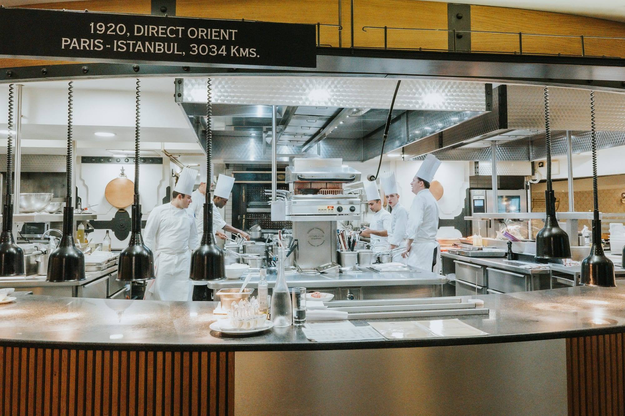 Brigade de cuisine au pass d'une cuisine ouverte