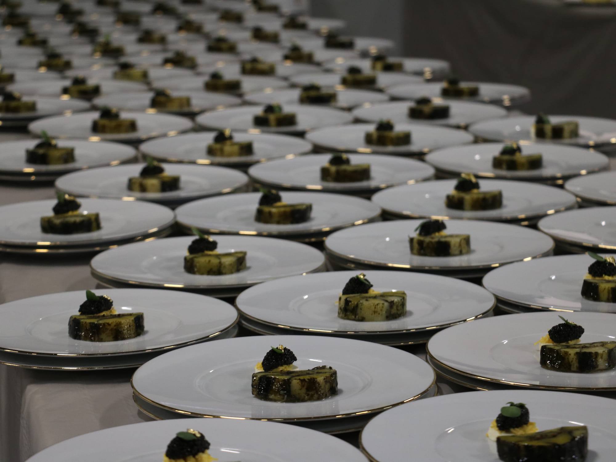 Dozens of identical plates lined up in rows, dressed for service
