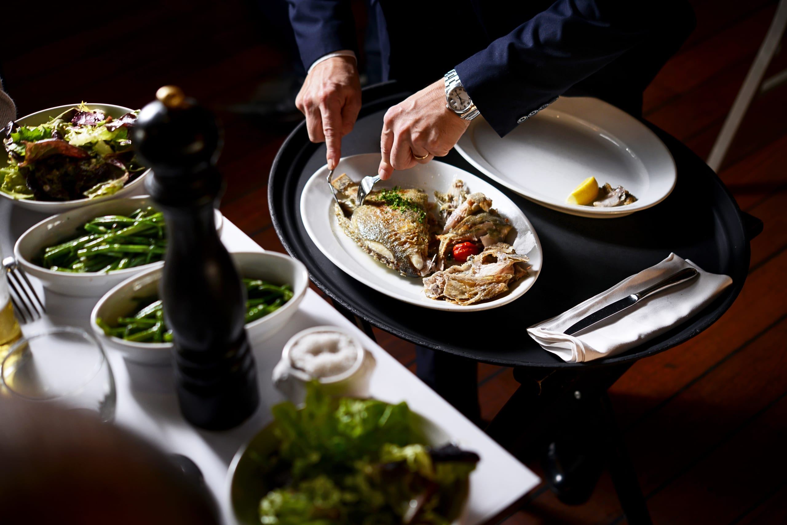 Service du poisson en salle dans une brasserie Bocuse, ambiance feutrée