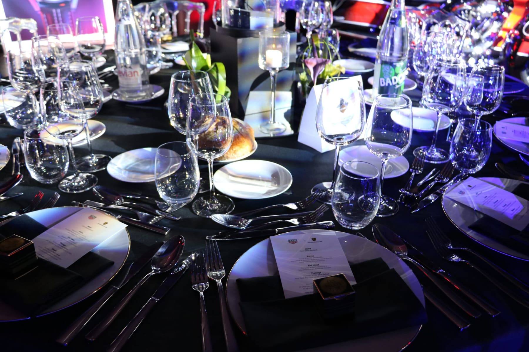Banquet table dressed in black with bread, menus and glassware ready for guests